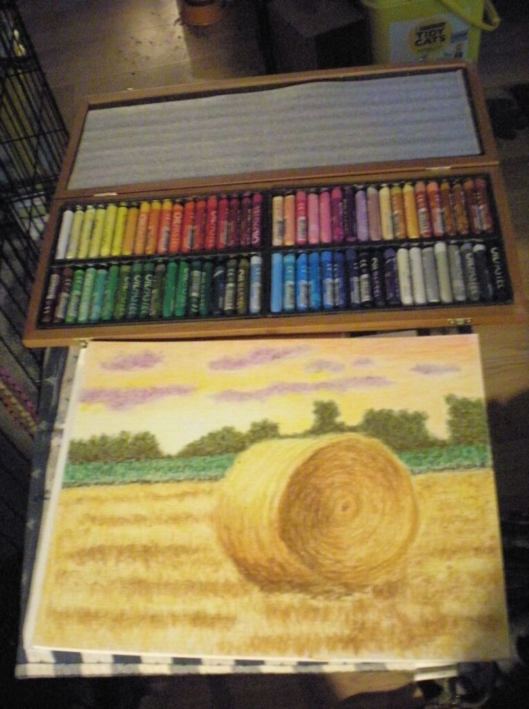 in-progress photo of my oil pastel landscape Sunset Over the Hayfield