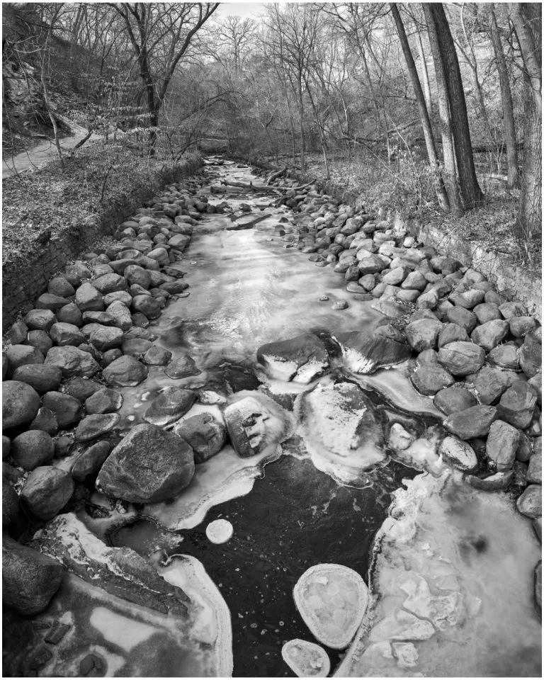 black and white photo of a partially frozen creek up in Minnesota